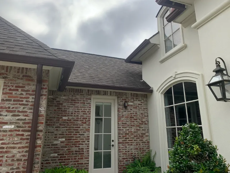 brown gutters white brick home livingston parish performance patios and gutters