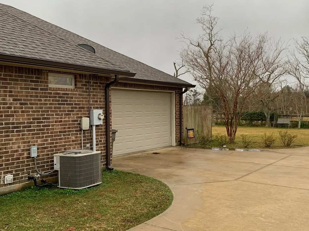 dark gutter system on red brick home near garage
