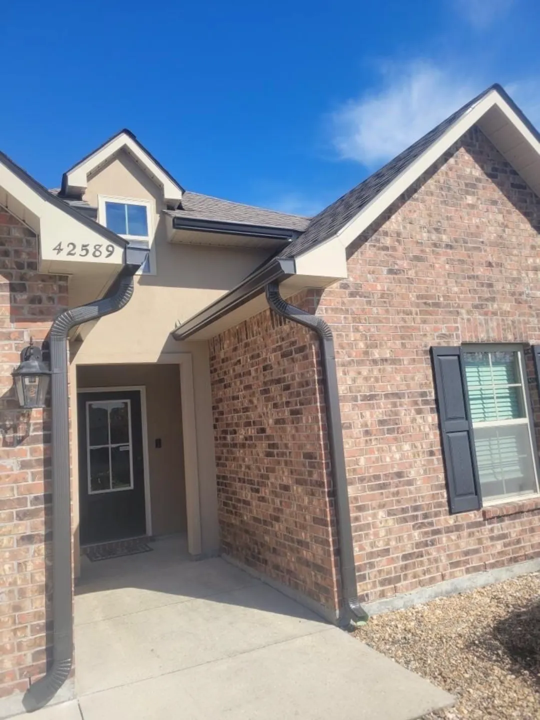 dark gutters brick stucco house geismar