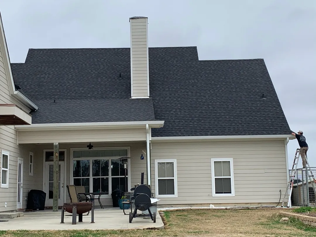 gutter installation on beige home with covered patio