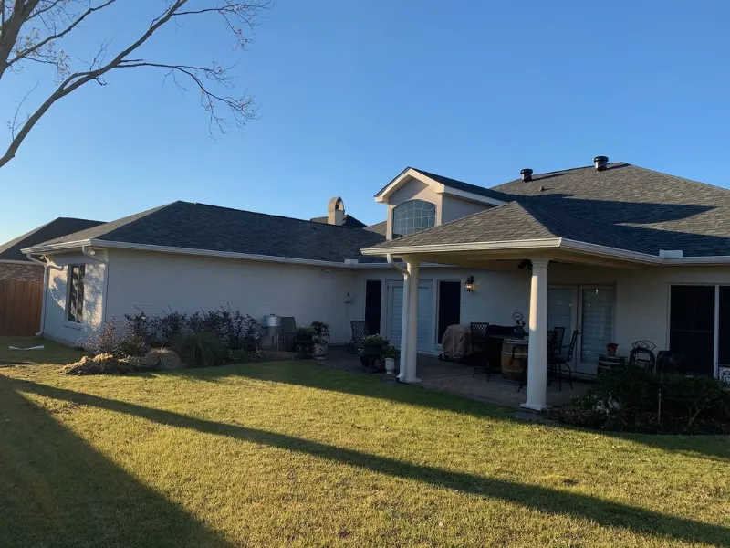 red brick home covered patio white gutters