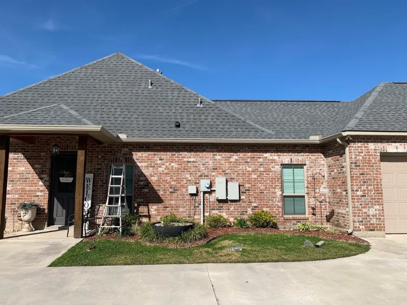 side view of brick home with welcome sign and blac