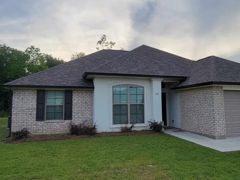 side view of home with gutters and landscaping in baton rouge