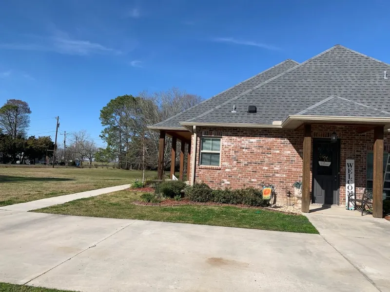side yard view showing wide open driveway and fron