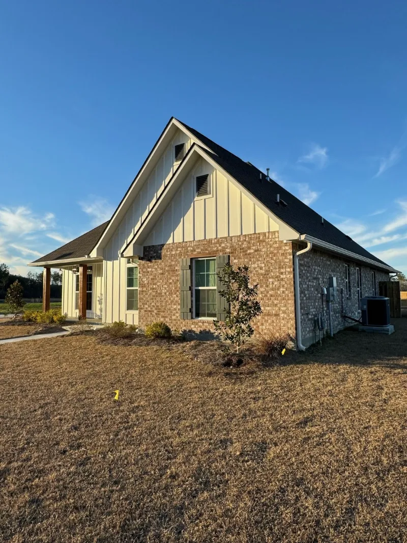 side yard view white board brick home