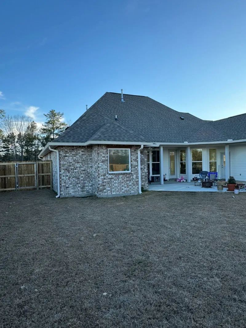 white brick home backyard patio white gutters