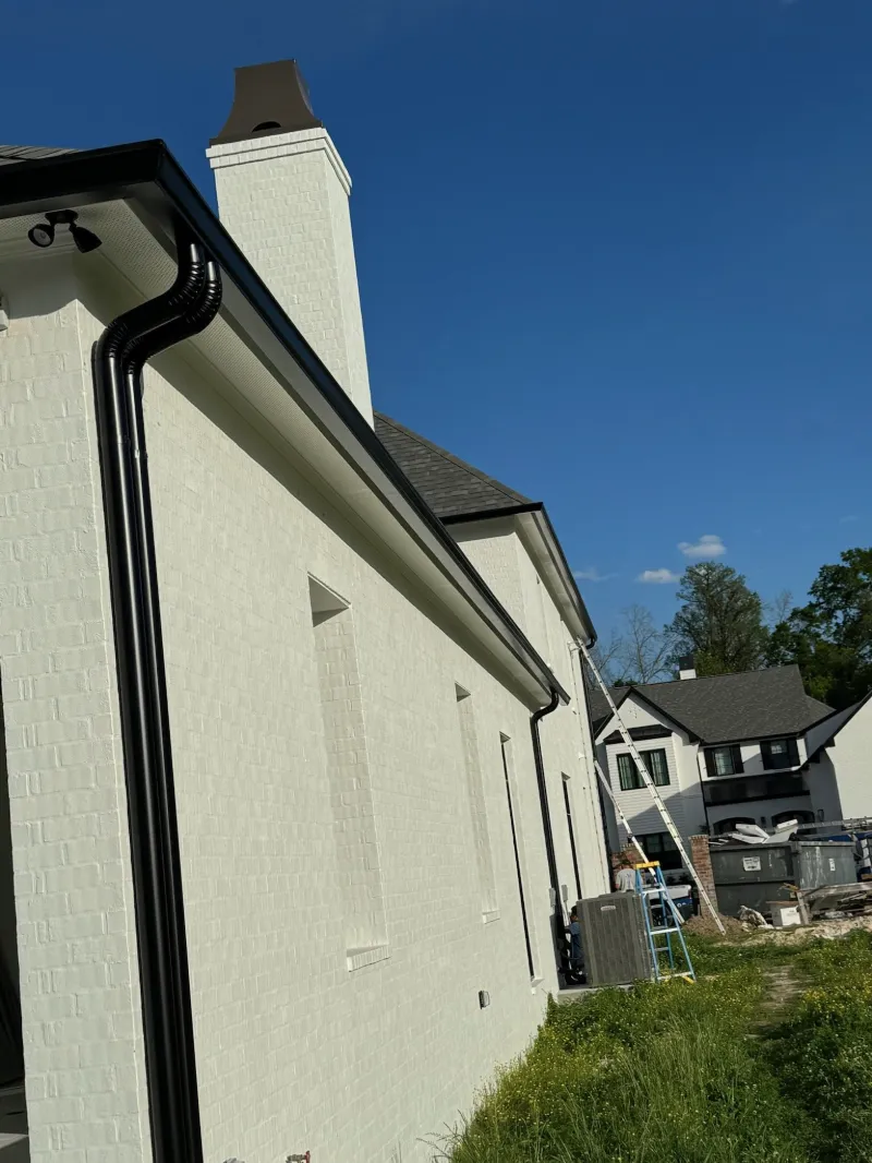 white brick home black downspouts installation zachary performance patios