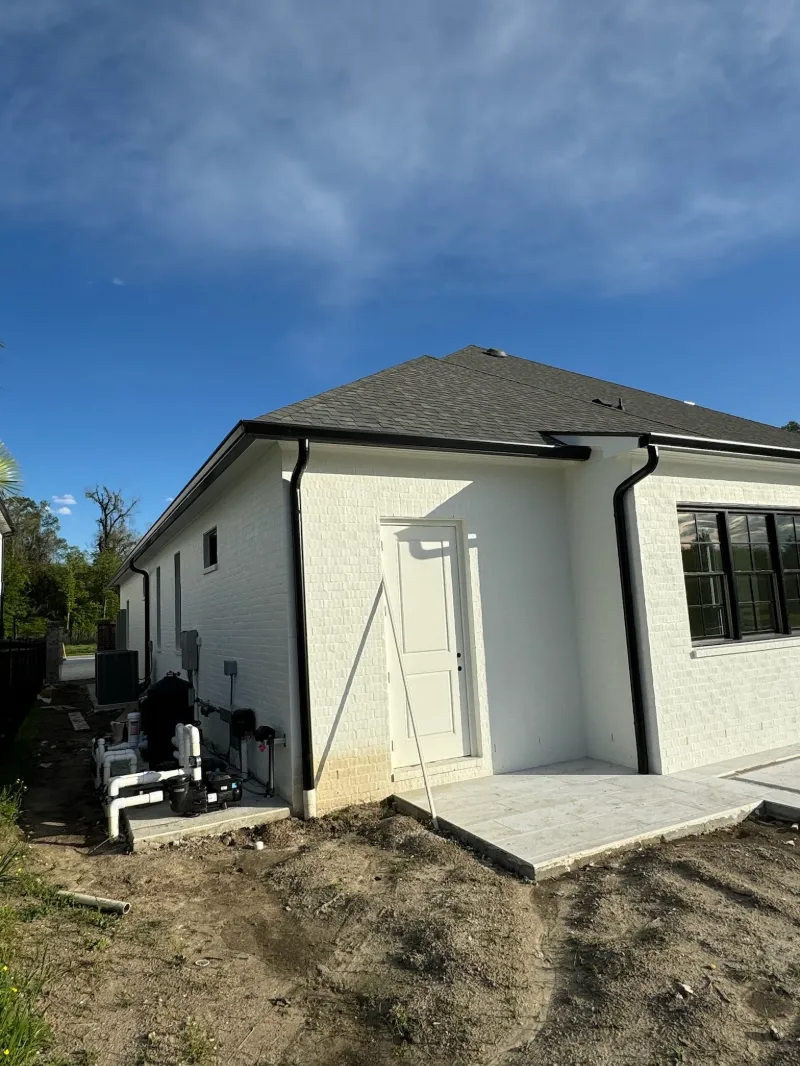 white brick home side yard gutter installation central baton rouge performance patios