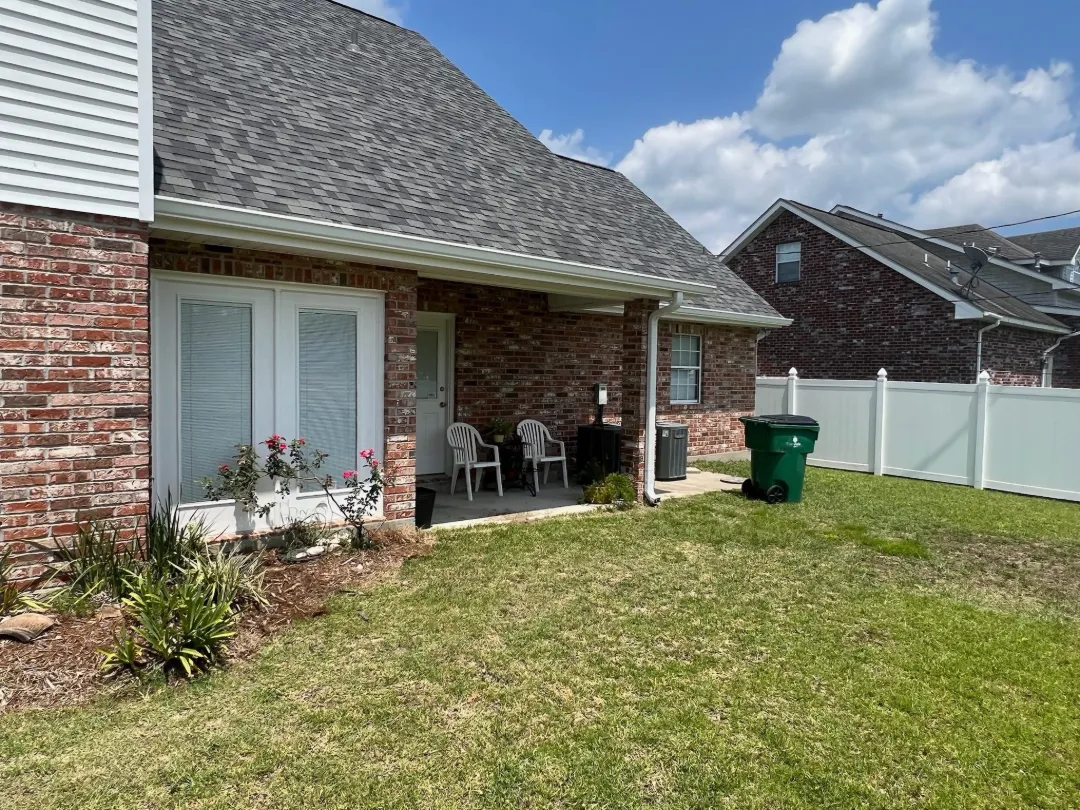 white gutters brick house back patio gonzales la