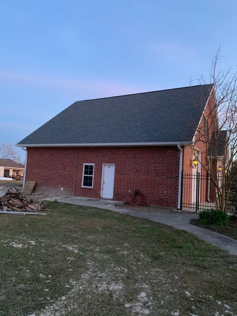 white gutters on large red brick home at dusk 1