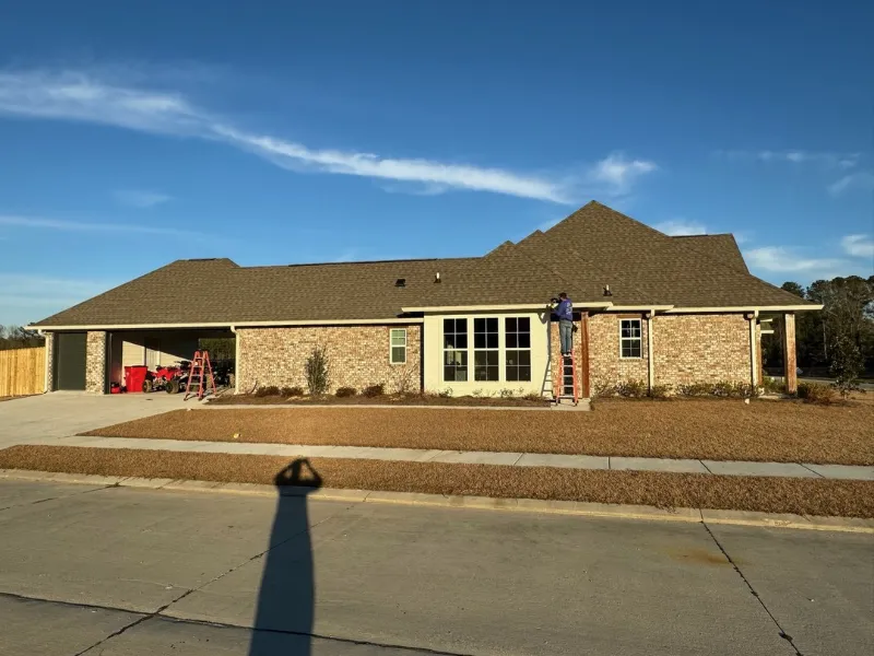 wide shot new home installing gutters