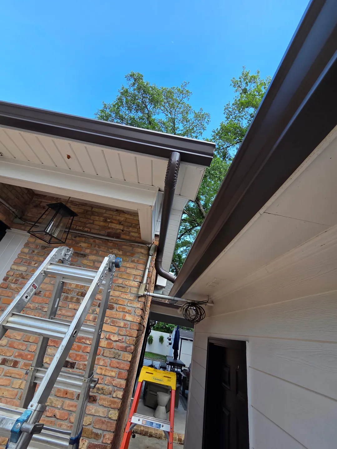 brown gutters corner brick home performance patios and gutters