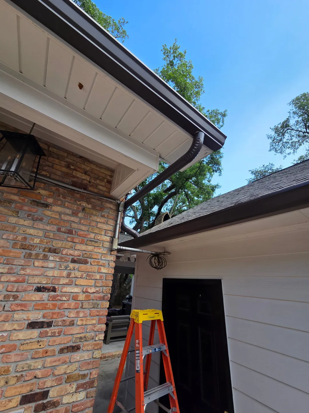 brown seamless gutters installation closeup performance patios and gutters