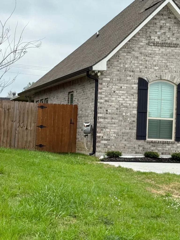 sideyard view light brick home black gutters performance patios and gutters