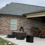 Covered patio attached to a brick home under a gray sky
